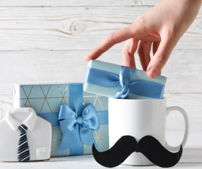 Prezent na Dzień Ojca – kubek z wąsem, upominki w niebieskim opakowaniu i ciastko w kształcie koszuli z krawatem